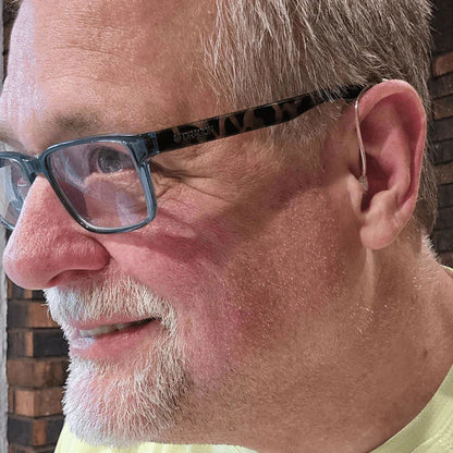 Close-up of a man wearing glasses with a blurred background