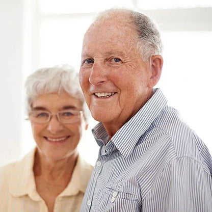 Two elderly people smiling against a white background